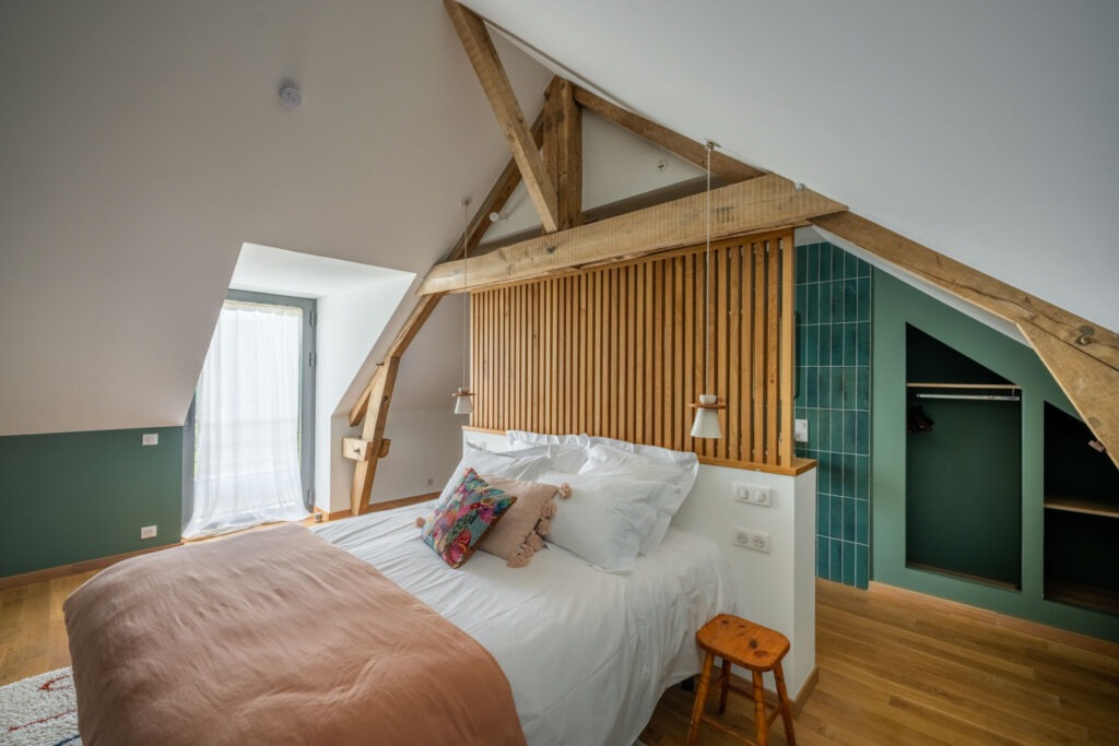 Chambre familiale avec charpente apparente et décoration naturelle dans le Lot