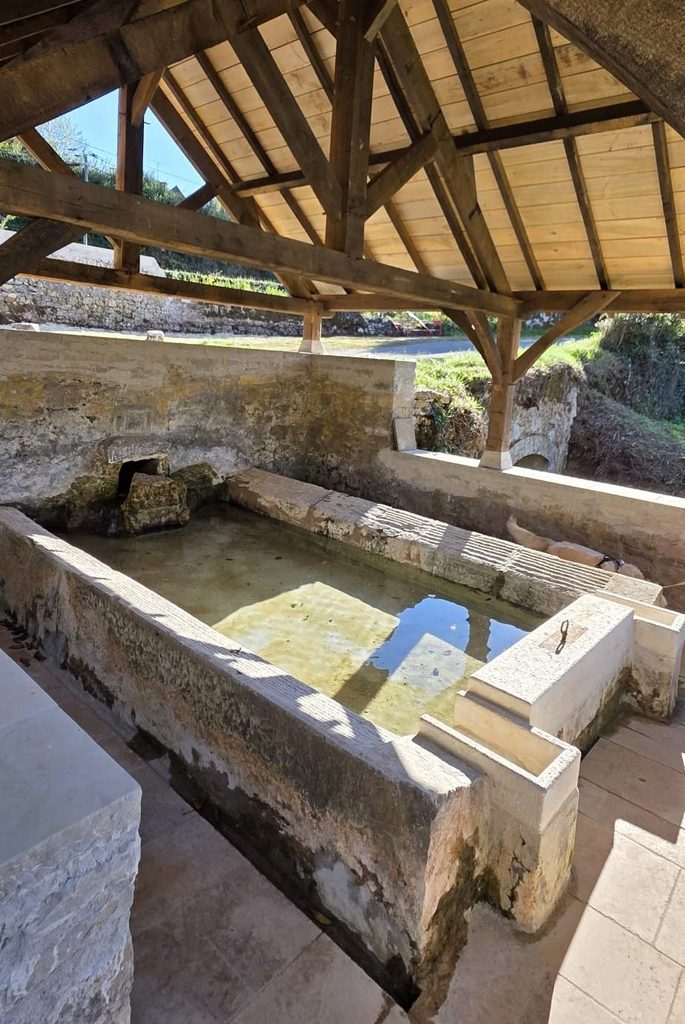 Lavoir traditionnel de Floirac Ancien lavoir en pierre abrité sous une charpente en bois à Floirac, dans la vallée de la Dordogne